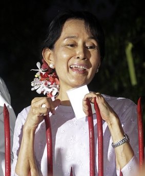Myanmar's pro-democracy leader Aung San Suu Kyi talks to the supporters as she stands at the gate of her home Saturday, Nov. 13, 2010 in Yangon, 
