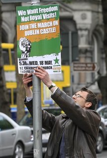 A protester puts up a placard to protest at the visit by Britain's Queen Elizabeth II to Ireland, Monday, May, 16, 2011.  Queen Elizabeth II begins a four day visit to Ireland on Tuesday for the first time since Irish Independence.  (AP Photo/Peter Morrison)